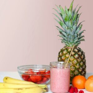 A vibrant smoothie with pineapple, banana, and berries, showcasing healthy freshness.